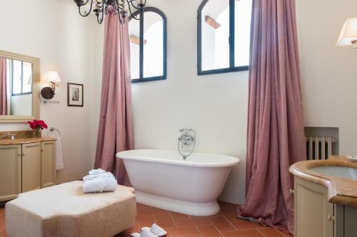 a bathroom with a large white tub and a window at Viesca Toscana Suites & Villas in Reggello