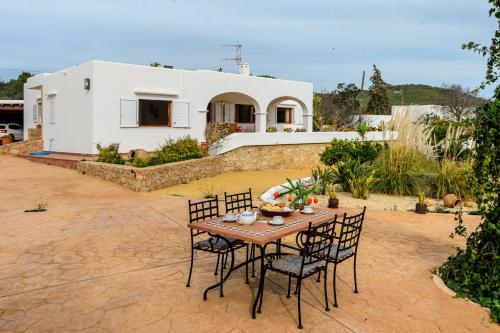 een patio met een tafel en stoelen voor een huis bij New! Villa Can Blai in Santa Eularia des Riu