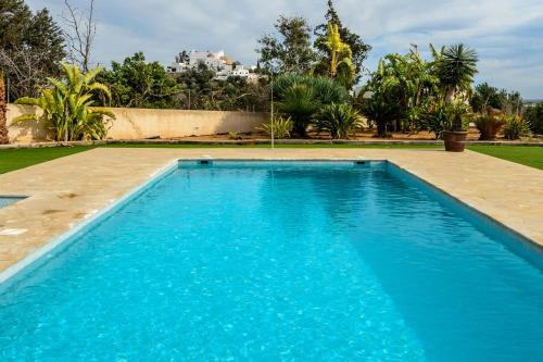 a large blue swimming pool in a yard at New! Villa Can Blai in Santa Eularia des Riu