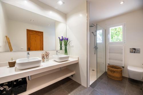 a bathroom with two sinks and a shower at New! Villa Can Pere Blai in Santa Eularia des Riu