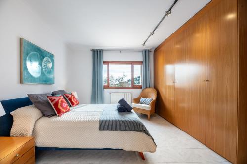 a bedroom with a bed and a wooden wall at New! Villa Can Pere Blai in Santa Eularia des Riu