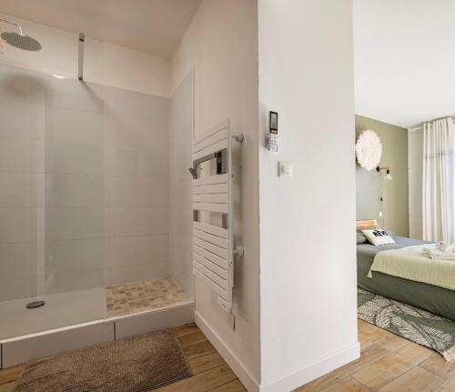 a white bathroom with a tub and a bed at Face à l'Arbre Blanc, Neuf Clim Parking in Montpellier