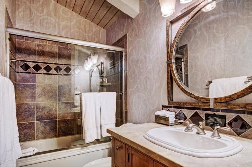 a bathroom with a sink and a tub and a mirror at Lodge at Vail, A RockResort in Vail