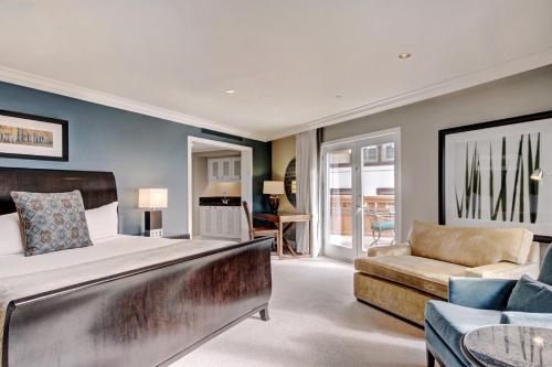 a bedroom with a bed and a living room with a couch at Lodge at Vail, A RockResort in Vail