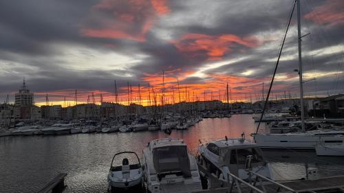 a group of boats docked in a marina at sunset at Cap Saint Martin Marina in Cap d'Agde