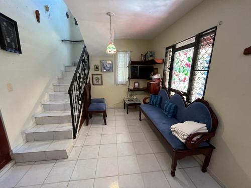 a living room with a blue couch and stairs at Sana El Jardin Secreto in Santiago de los Caballeros