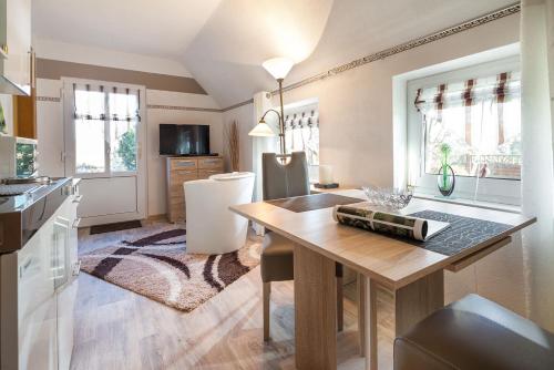 uma cozinha com uma mesa e uma sala de jantar em Haus Naase App 3 em Norderney