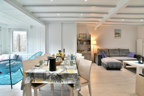 una sala da pranzo e un soggiorno con tavolo e sedie di Maison Castine - Maison pour 6 a Saint-Cast-le-Guildo