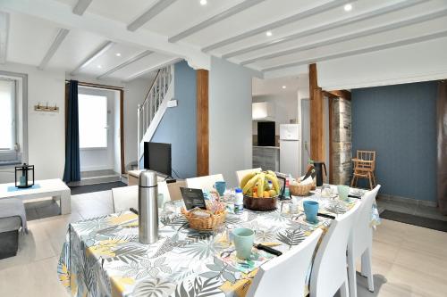 - une salle à manger avec une table et des chaises blanches dans l'établissement Maison Castine - Maison pour 6, à Saint-Cast-le-Guildo