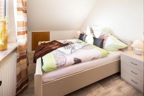 Un dormitorio con una cama con almohadas. en Haus Naase App 2 en Norderney