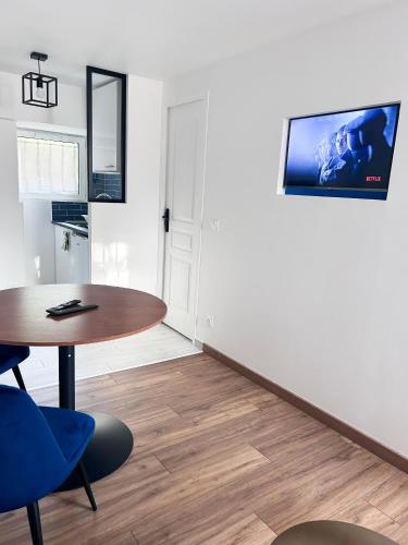 Cette chambre dispose d'une table et d'une télévision murale. dans l'établissement Cosy home proche de Roissy CDG PARIS, Parc Astérix I Aéroville I Parc des Expo I Villepinte, à Louvres