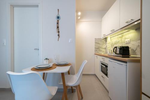 a kitchen with a small table and chairs in a kitchen at ALMIRA Studios Limnos 2 in Mirina