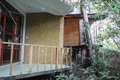 a porch of a house with a wooden railing at Seasons Four Eco Friendly Treehouse in Matara