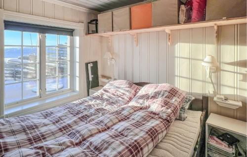 a bedroom with a bed with a plaid blanket and a window at Stunning Apartment In Beitostlen With Kitchen in Beitostøl