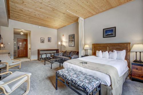 a bedroom with a large bed and a living room at Gateway Mountain Lodge by Keystone Resort in Keystone