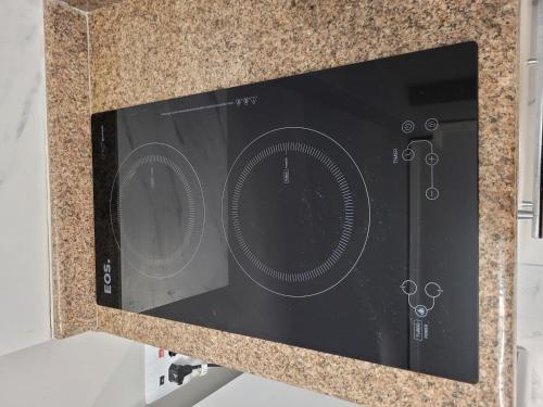 a black microwave on top of a counter at De frente para o Guaíba. in Porto Alegre