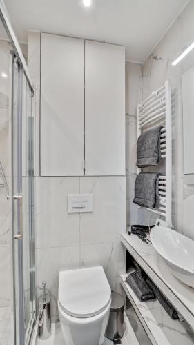 une salle de bain blanche avec des toilettes et un lavabo dans l'établissement 07 Tour Eiffel - Maison pour 5 personnes, à Paris