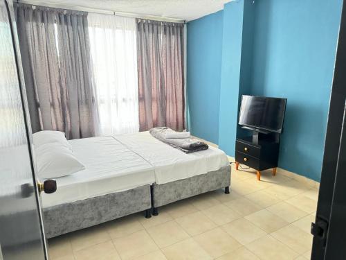 um quarto com uma cama e uma televisão de ecrã plano em Apartamento completo con terraza y piscina em Armênia
