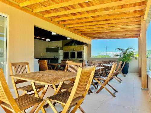 邦比尼亞斯的住宿－Residencial 287 - Localização privilegiada à 5min da praia，一间带木桌和椅子的用餐室