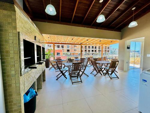邦比尼亞斯的住宿－Residencial 287 - Localização privilegiada à 5min da praia，一间带桌椅的用餐室和一个阳台