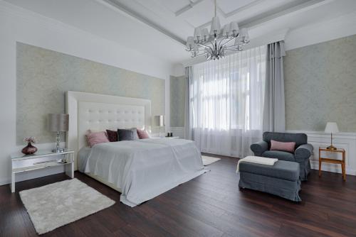 - une chambre blanche avec un grand lit et une chaise dans l'établissement UPP Design Home, à Budapest