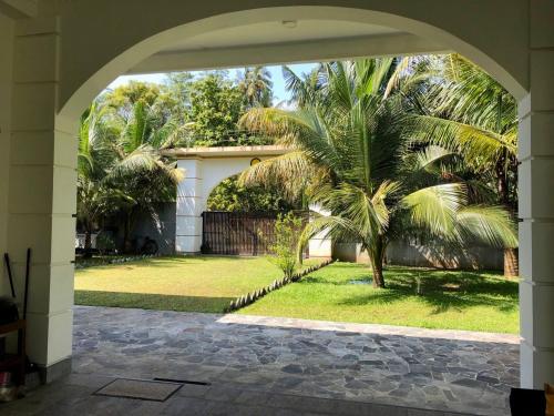 an archway with a palm tree in front of a house at Villa La more in Unawatuna
