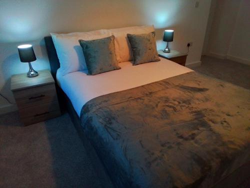 a bedroom with a large bed with two night stands at Apartment 13, Plants Yard in Worksop