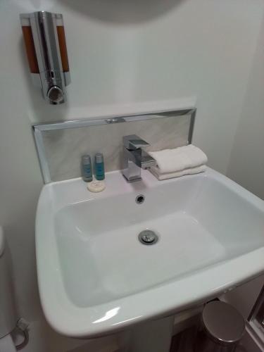 a white bathroom sink with a chrome faucet at Apartment 13, Plants Yard in Worksop
