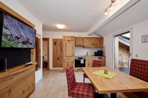 kuchnia i jadalnia z drewnianym stołem i krzesłami w obiekcie Wellness-Appartements Berchtesgadener Land w mieście Ainring