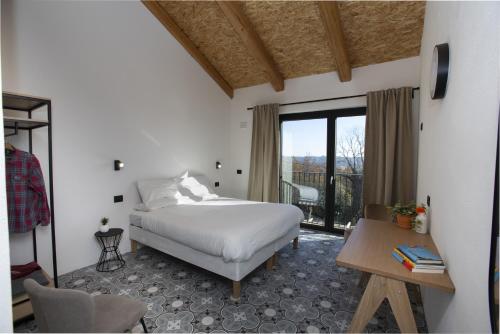 a bedroom with a bed and a table and a window at Cascina Rüral in Montafia