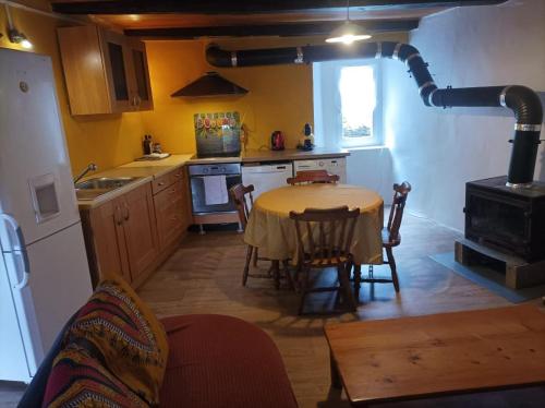 a kitchen with a table and chairs in a room at le Pountil in Valgorge