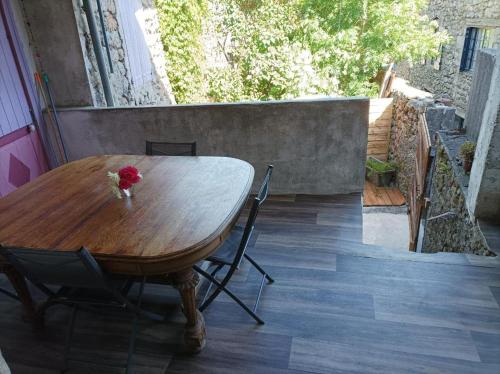 a wooden table with a vase of flowers on it at le Pountil in Valgorge