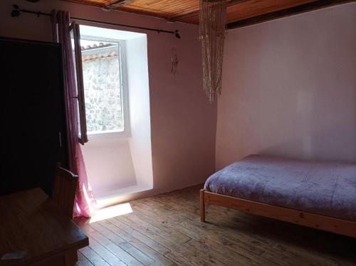 a bedroom with a bed and a window at le Pountil in Valgorge
