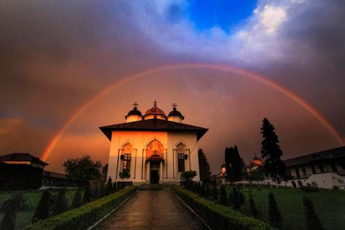 a rainbow in the sky over a building at Adac Boutique Hotel in Bucharest