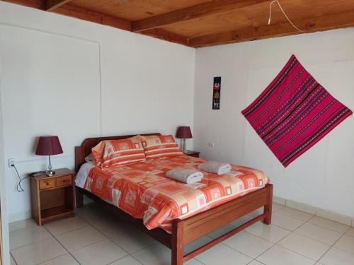 1 dormitorio con 1 cama y 1 mesa con lámpara en CASA LLARETA, en San Pedro de Atacama