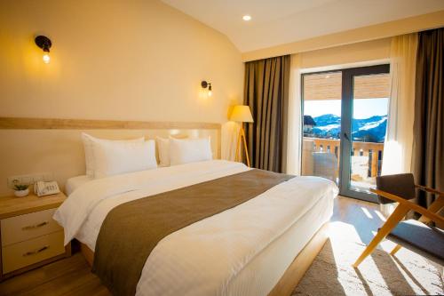 um quarto de hotel com uma cama grande e uma varanda em Gudauri Inn em Gudauri