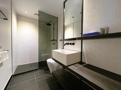 La salle de bains est pourvue d'un lavabo, de toilettes et d'une douche. dans l'établissement 2BR 1 Bath, Dockland, Marvel Stadium, Spacious, à Melbourne