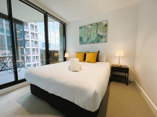 - une chambre avec un grand lit blanc et des oreillers jaunes dans l'établissement 2BR 1 Bath, Dockland, Marvel Stadium, Spacious, à Melbourne