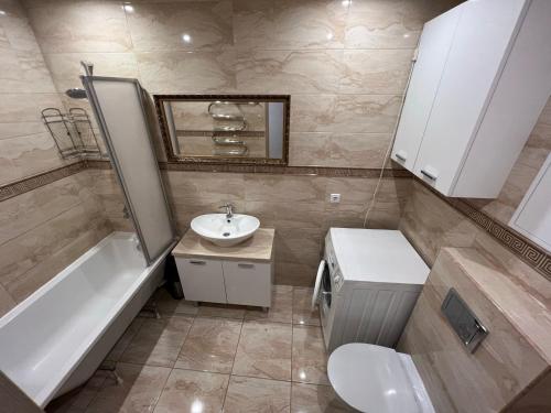 a bathroom with a sink and a toilet and a bath tub at Forentinn Kranto 43 in Panevėžys