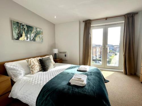 a bedroom with a large bed and a large window at Beachfront Bliss with Spectacular Views in Llanelli