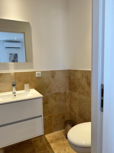 a bathroom with a white sink and a toilet at Résidence Terminus - appartements in Sainte-Maxime