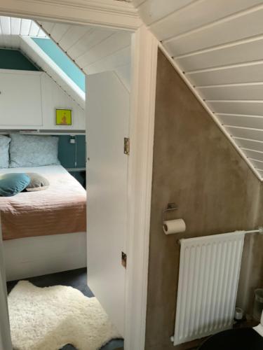 ein kleines Zimmer mit einem Bett und einer Treppe in der Unterkunft Spiced Bed&Breakfast in Nykøbing Falster