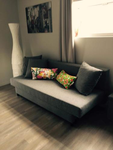 a couch with pillows on it in a living room at Holiday home Poire et Table in Wingene