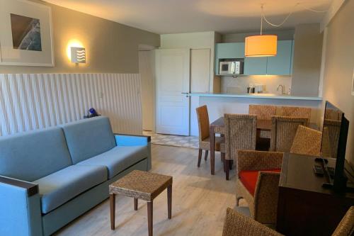 un soggiorno con divano e sala da pranzo di Bel appartement 5 pers avec piscine tennis et parking 236 a Le Touquet-Paris-Plage