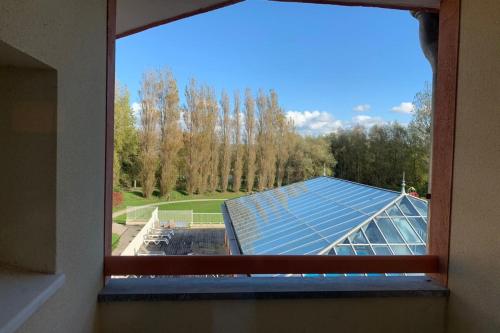 une fenêtre avec vue sur un bâtiment avec solarium dans l'établissement 5-person flat with swimming pool tennis court and private parking 236, à Le Touquet-Paris-Plage