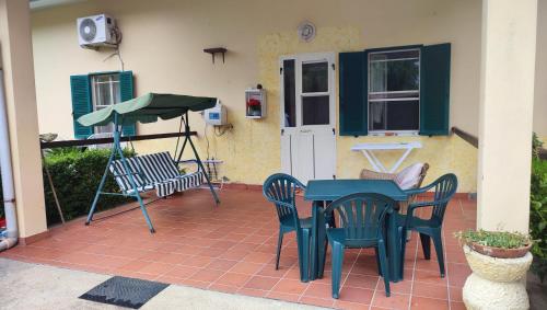 une terrasse avec une table et des chaises ainsi qu'une maison dans l'établissement L'oasi del relax Arborea, à Arborea