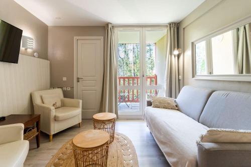 salon z kanapą, stołem i krzesłami w obiekcie Beautiful flat with swimming pool tennis court and free parking 117 w mieście Le Touquet-Paris-Plage