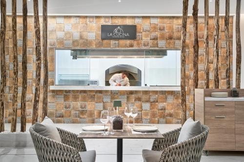 a dining room with a table and two chairs at Lindos Grand Resort & Spa - Adults Only in Líndos