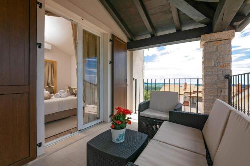 a room with a balcony with a couch and a bed at Villa Bellevue in Sveti Lovreč Pazenatički