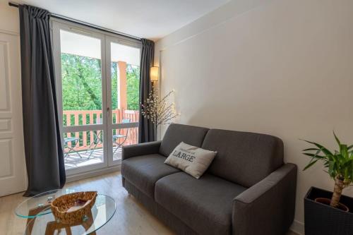 un salon avec un canapé et une table en verre dans l'établissement Beautiful flat with swimming pool tennis court and private car parking 109, à Le Touquet-Paris-Plage